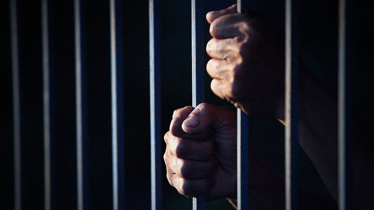 A picture of hands gripping prison bars.