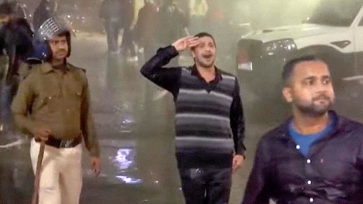 A student saluting as the police use water cannons against him in Patna.
