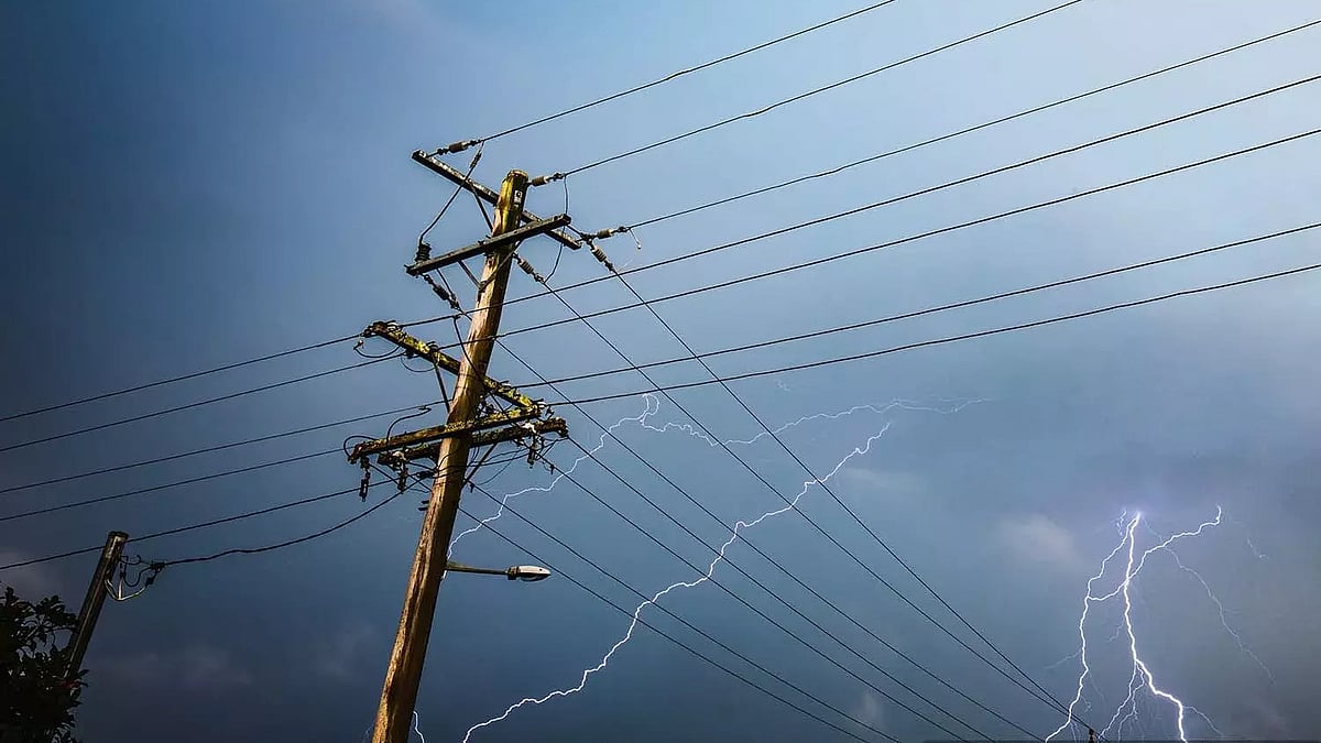 A power line with lightning flashing behind it.