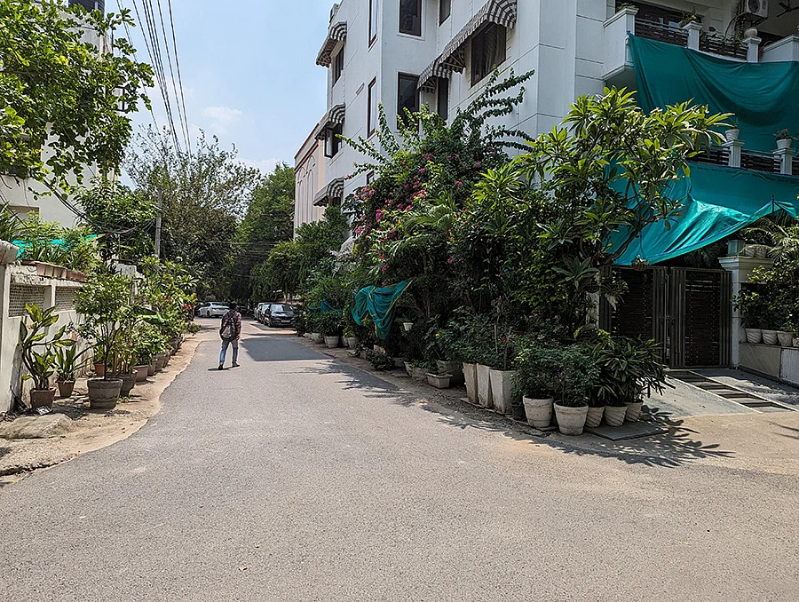 A road in Defence Colony with potted plants encroaching the footpaths 