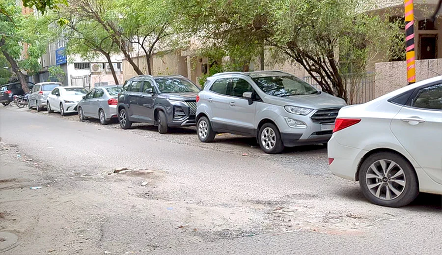 Cars parked on a footpath in Delhi's Greater Kailash