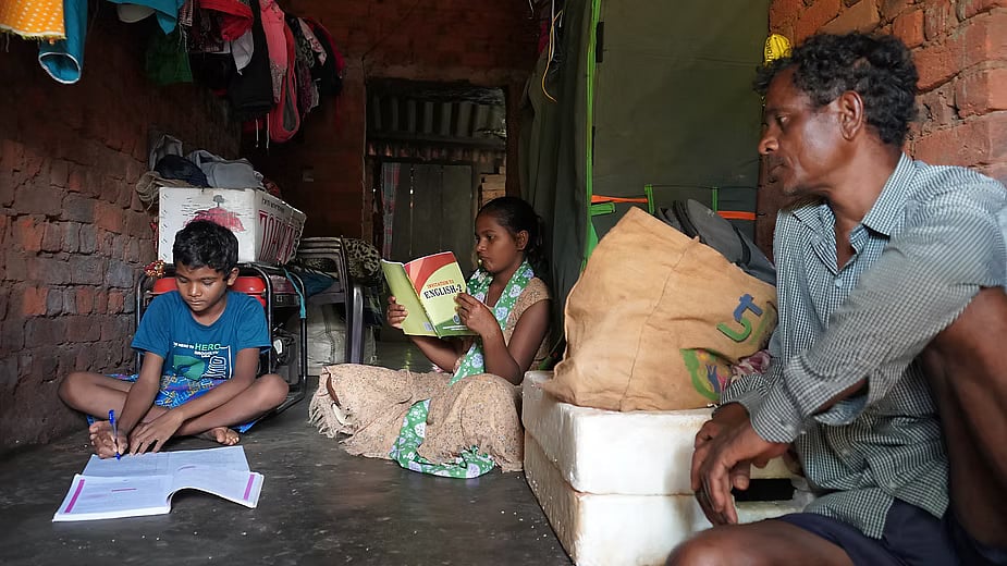 Dana Majhi with his youngest son and only daughter at their home in Dhamanguda village which is filled with sound systems and other equipment as the family builds an entertainment business.