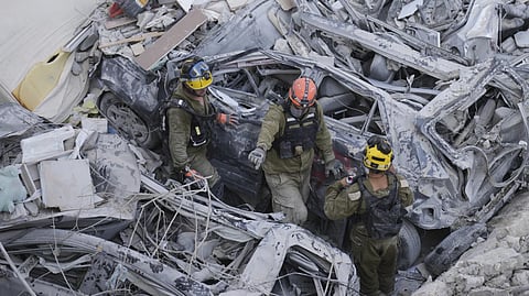 Israeli soldiers dig through rubble to search for survivors after a residential area is hit by an Iranian missile.