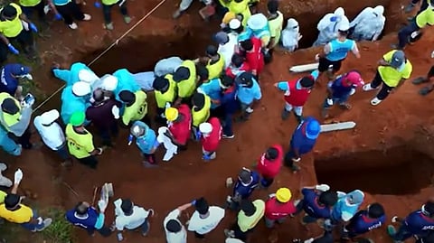 ഉരുളെടുത്തവർ ഒന്നിച്ച് മണ്ണോട് ചേർന്നു, പുത്തുമലയിൽ ഇനി അന്ത്യവിശ്രമം; കുഴിമാടത്തിൽ ഡിഎൻഎ സാംപിൾ നമ്പറും