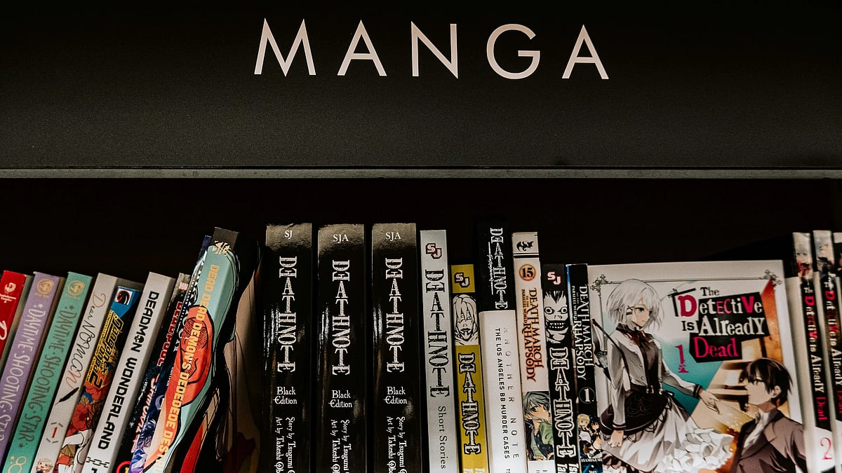 Shelf of manga books including Death Note and The Detective Is Already Dead under a “MANGA” sign.