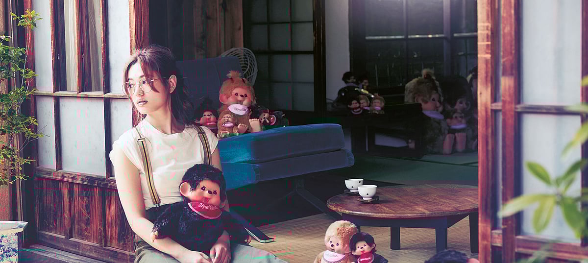 Monchhichi held by woman in an interior setting.