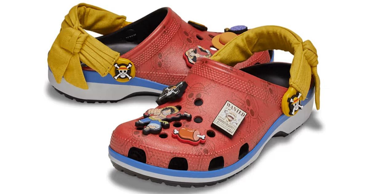 One Piece x Crocs Monkey D. Luffy Classic Clog in red with blue midsole, yellow sash strap, and Jibbitz charms including a wanted poster and straw hat