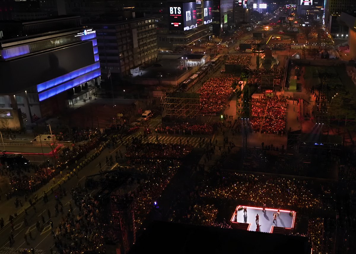 Audience hauling around BTS Gwanghwamun concert stage (on right). Screen Captured from BTS Netflix Live.