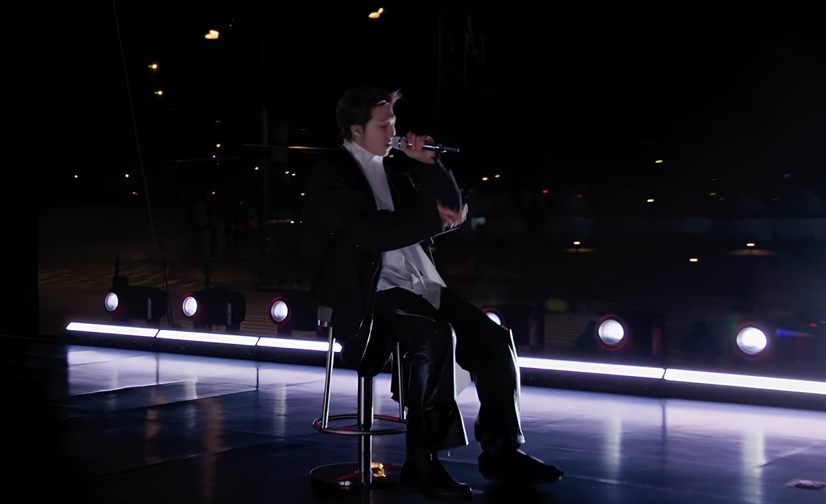 Injured RM seated in a chair while performing. Screen Captured from Netflix Live BTS The Comeback.
