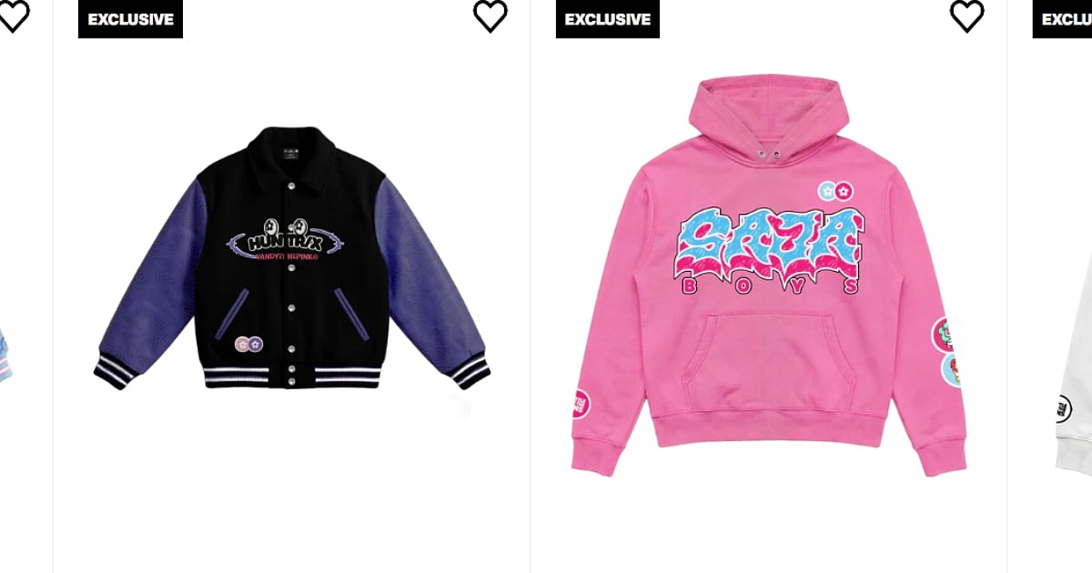 The two exclusive streetwear pieces from the VANDYTHEPINK x KPop Demon Hunters collection. On the left is a black varsity jacket with purple textured sleeves and the HUNTR/X logo on the chest. On the right is a vibrant pink hoodie featuring "SAJA BOYS" in a blue and pink graffiti-style font, accented with small character patches on the sleeves. Both items are labeled with "EXCLUSIVE" tags and heart icons.