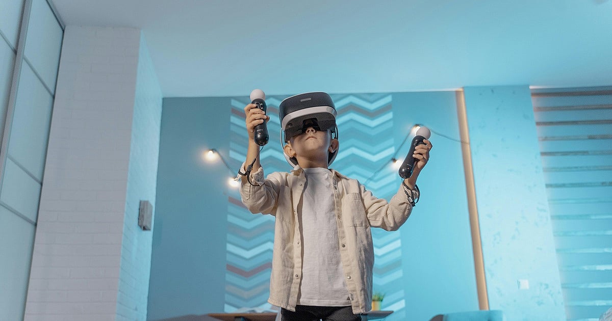 A young gamer playing on a VR headset with two controllers