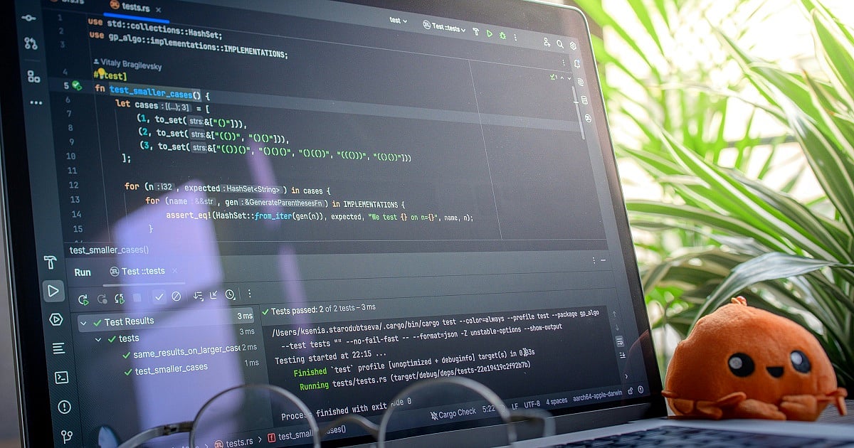 Open laptop displaying code next to a plush toy in ab right room