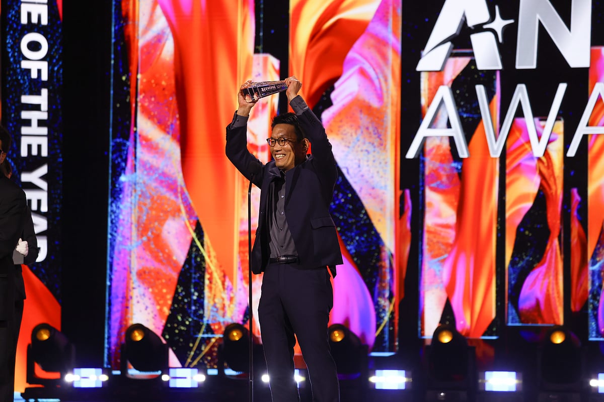 My Hero Academia Director Kenji Nagasaki holding the Anime of the Year Award above his head in a celebratory stance