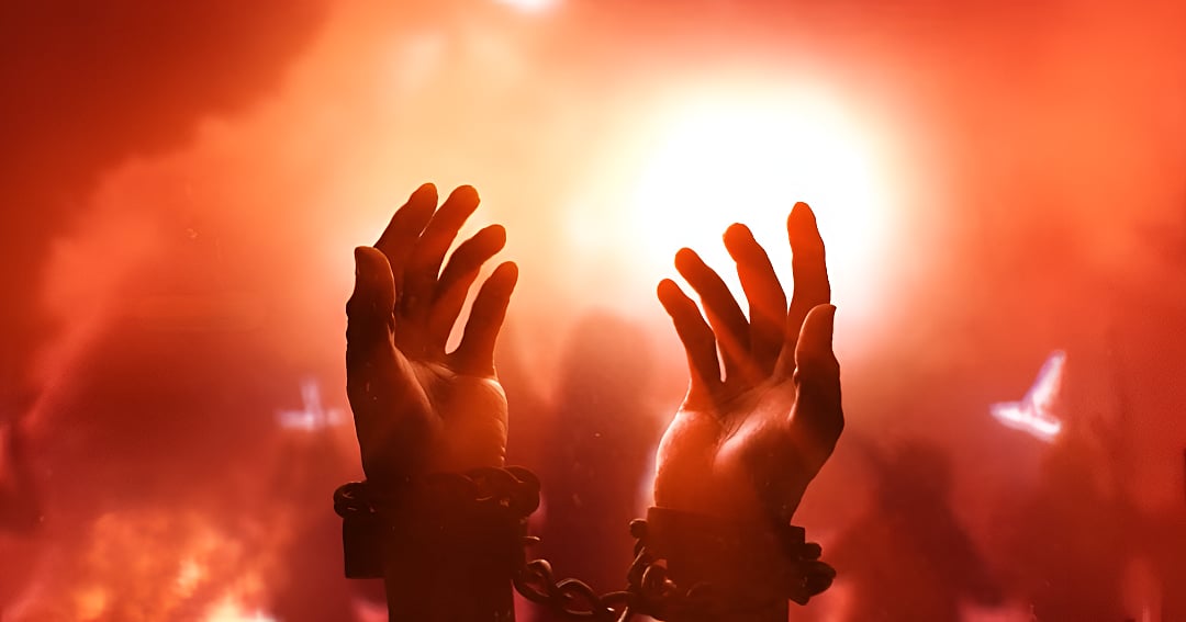 Hands in chains raised toward a bright red light in the Far Cry 6 cinematic trailer.