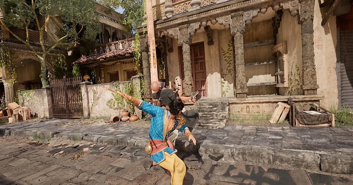 Gameplay screenshot from Unleash the Avatar showing the protagonist Vikram in a blue tunic and yellow pants delivering a powerful strike that launches an enemy backward through the air. The fight takes place on a sunlit stone street lined with traditional Indian-style buildings featuring carved pillars, balconies, creeping vines, and clay pots. 