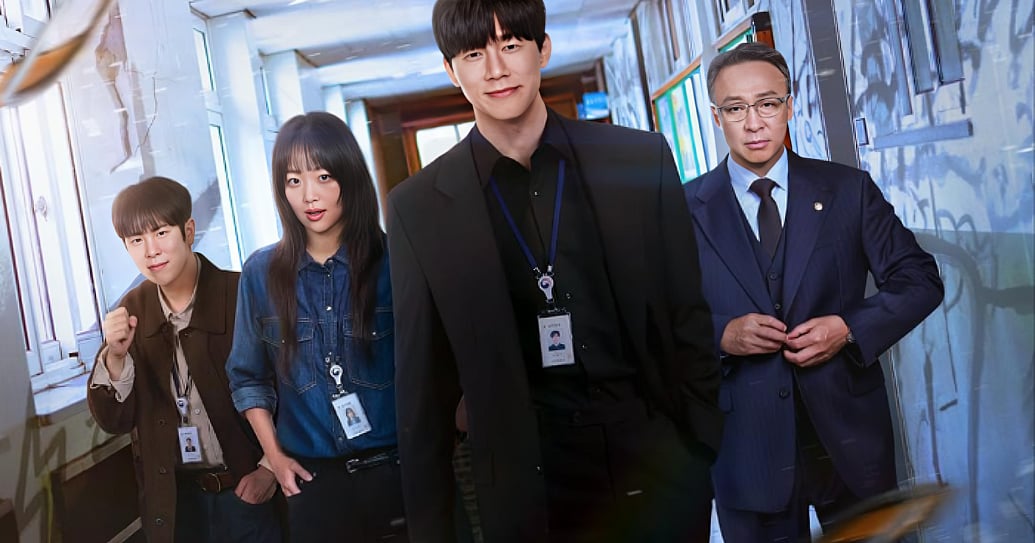 A promotional still featuring four characters walking forward in a staggered formation down a brightly lit institutional hallway. In the center foreground, a tall man with dark hair smiles subtly, wearing a black blazer over a black button-down shirt and an ID badge on a lanyard. To his right stands an older man with glasses and a serious expression, dressed in a formal navy blue three-piece suit and tie. To the center-left, a young woman with straight black hair and bangs looks ahead wearing a blue denim shirt and an ID lanyard. On the far left, a young man with a bowl-cut hairstyle poses with a raised fist, wearing a brown jacket over a beige shirt and an ID lanyard. The background shows a slightly weathered corridor with large windows on one side letting in bright daylight. TEACH YOU A LESSON on NETFLIX. K-Drama.