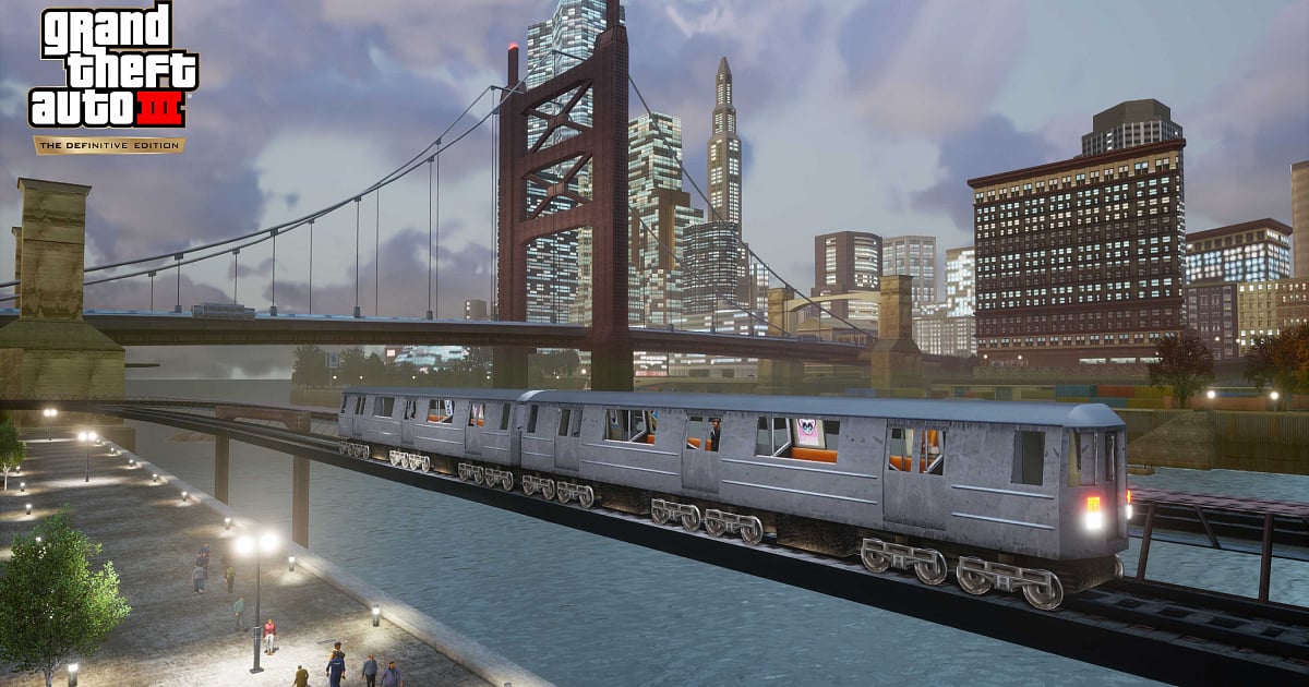 Promotional screenshot for Grand Theft Auto III: The Definitive Edition. The game's logo appears in the upper-left corner.
There's silver subway train traveling across an elevated railway bridge. The train consists of several connected cars with lit interiors.
Behind the train, a large suspension bridge with rust-red steel towers spans the water. Beyond it, a dense city skyline.
In the foreground, a waterfront promenade runs alongside the water beneath the railway.