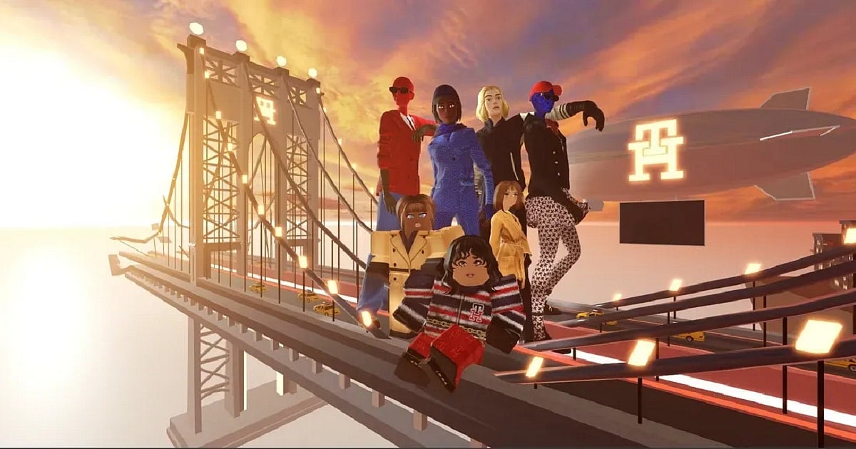 A group of seven Roblox avatars pose together on the cables and framework of a large suspension bridge at sunset, creating a high-fashion editorial-style scene. The avatars wear a variety of colorful, stylish outfits, including tailored suits, dresses, patterned pants, and striped knitwear, with one character seated in the foreground while the others stand behind in confident poses.