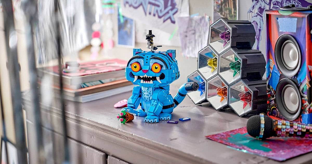 LEGO KPop Demon Hunters Derpy Tiger figure displayed with colorful props and a speaker in the background.
