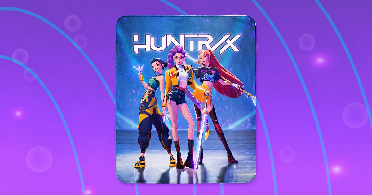 A HUNTR/X blanket featuring Rumi, Mira, and Zoey from KPop Demon Hunters, displayed against a purple background with glowing blue arcs and light effects.