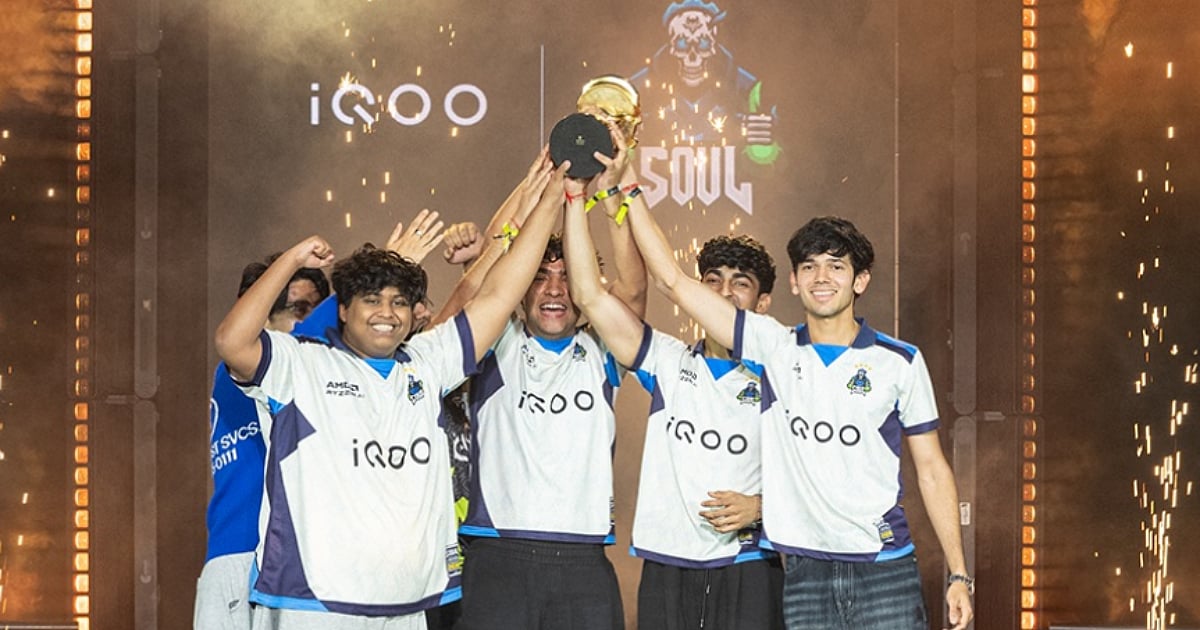 iQOO SouL players celebrate their BMSD 2026 victory by raising the championship trophy on stage amid pyrotechnics.