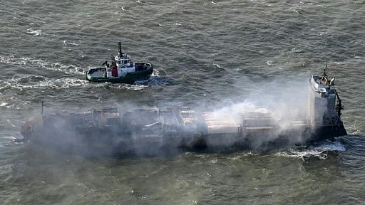 A tugboat accompanies the stricken Solong cargo ship following a devastating crash in the North Sea