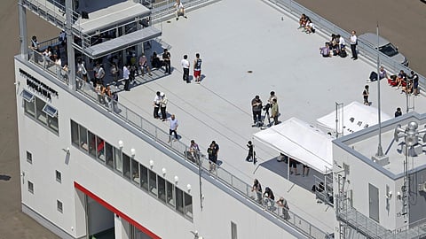 People take shelter on the roof of a fire station in Mukawa town, Hokkaido, northern Japan on Wednesday, July 30, 2025