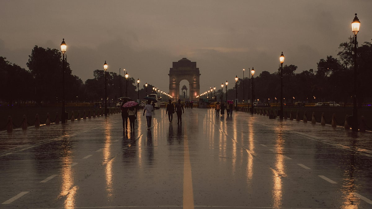 Photo by Pramod  Tiwari : People walk with umbrellas during sudden October rain in New Delhi