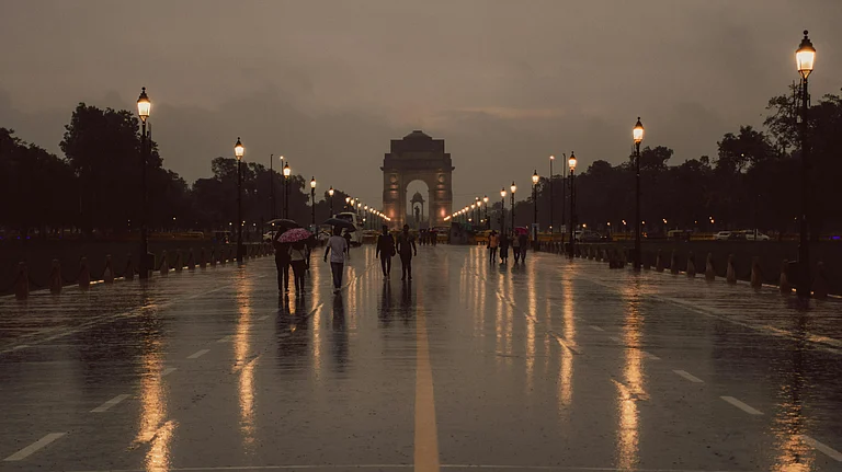 People walk with umbrellas during sudden October rain in New Delhi - Photo by Pramod  Tiwari