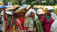 Photo by PTI : Rain-soaked streets of Delhi as people shield themselves with disposable plates and cardboard