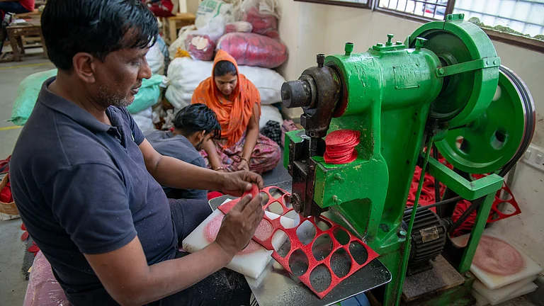 Worker cutting the four quarters shape from leather piece by leather cutting machine at Factory in Meerut - null