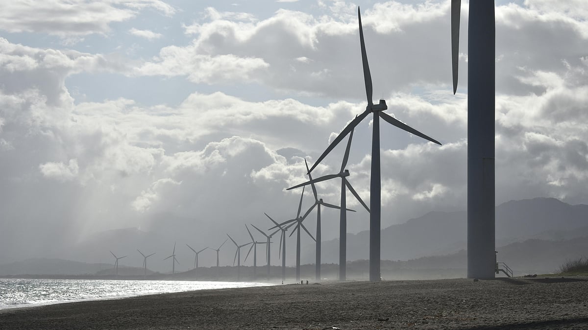 Photo by Jem  Sanchez : Wind turbines under cloudy skies at a renewable energy park