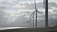 Photo by Jem  Sanchez : Wind turbines under cloudy skies at a renewable energy park