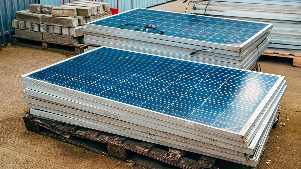 Discarded solar panels stacked for recycling at a renewable energy facility in India - null