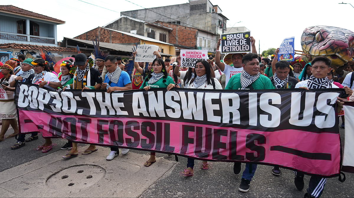 Photo by AP : Activists march at a climate protest during the COP30