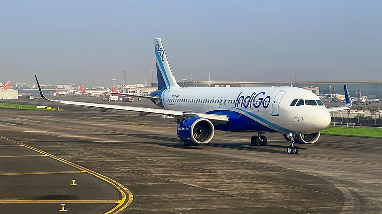 An IndiGo aircraft parked on the tarmac at an Indian airport terminal - null