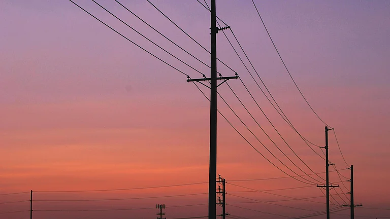 Power transmission lines against a sunset as India’s electricity demand rises - Photo by Chase Crawford