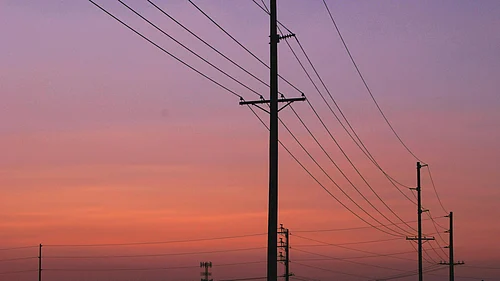 Photo by Chase Crawford : Power transmission lines against a sunset as India’s electricity demand rises