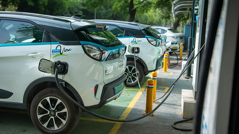 Electric vehicles charging at a public EV charging station in India - null