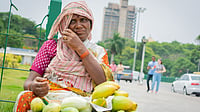 Street vendor Woman selling mango's and cucumber at hot sunny day at Bangalore, India