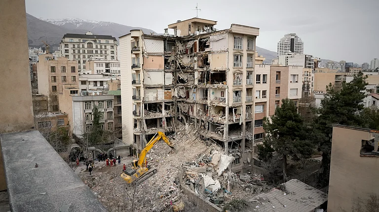 Iranian Red Crescent emergency workers use a bulldozer to clear rubble from a residential building that was hit in an earlier US-Israeli strike in Iran - null