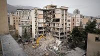 Iranian Red Crescent emergency workers use a bulldozer to clear rubble from a residential building that was hit in an earlier US-Israeli strike in Iran
