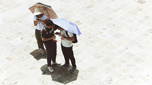 Photo by Alina Zhabynska : People shield themselves from intense heat during a hot day in Delhi