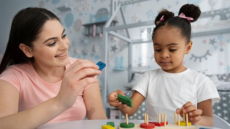 A woman and child playing with wooden blocks - null