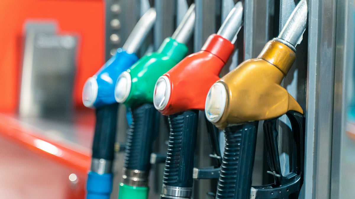 Fuel pump nozzle dispensing petrol amid rising global crude oil prices - null