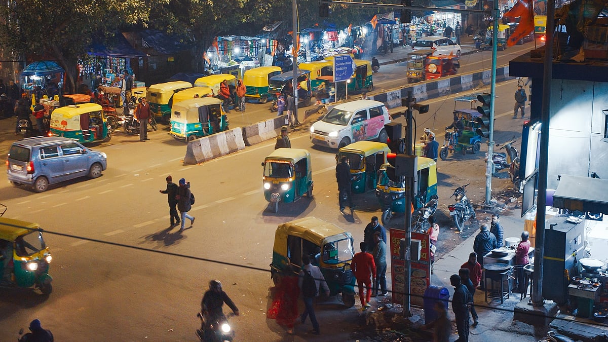 Auto-rickshaws and taxis line up on a busy road in New Delhi - null