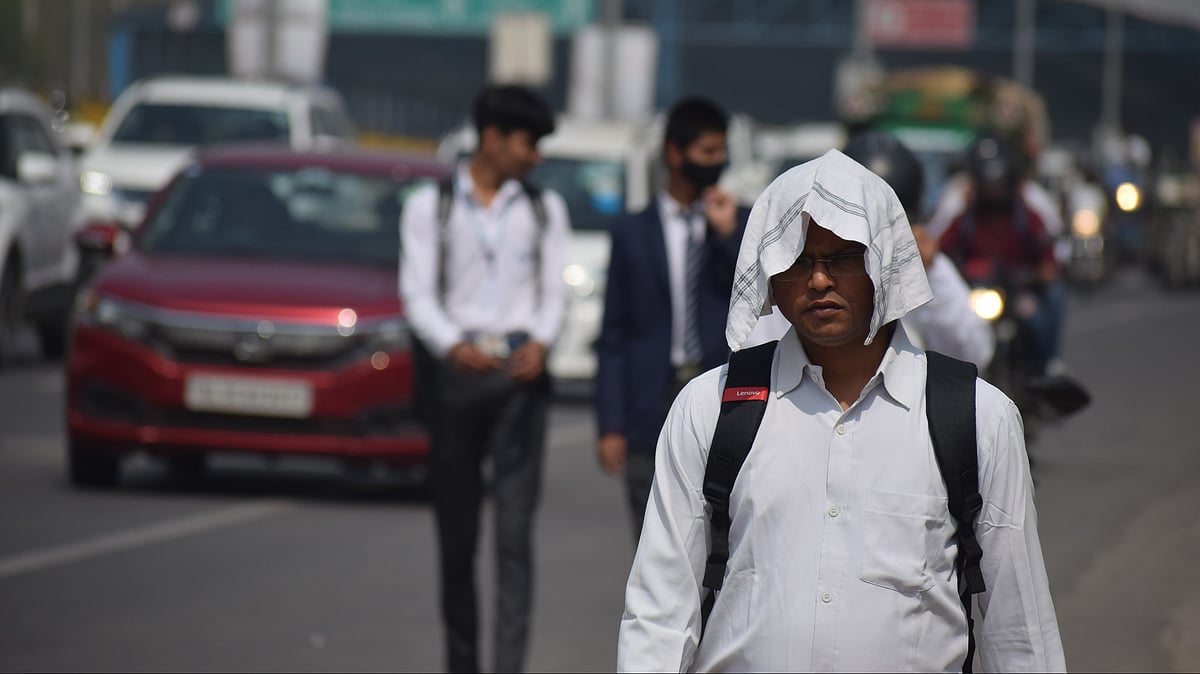 People shield themselves from scorching temperatures during ongoing heatwave conditions in Delhi - null
