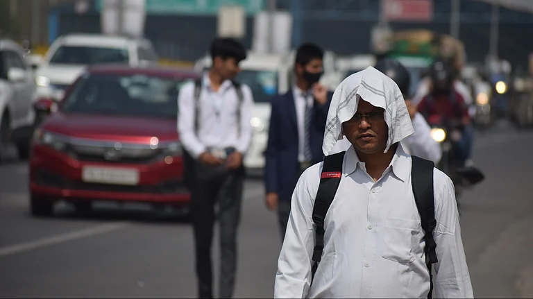 People shield themselves from scorching temperatures during ongoing heatwave conditions in Delhi - null