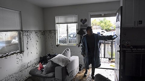 Tony Blas points to the water line inside his home that flooded during a rain storm Monday.