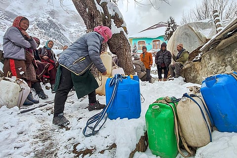 Residents collect water amid snowfall